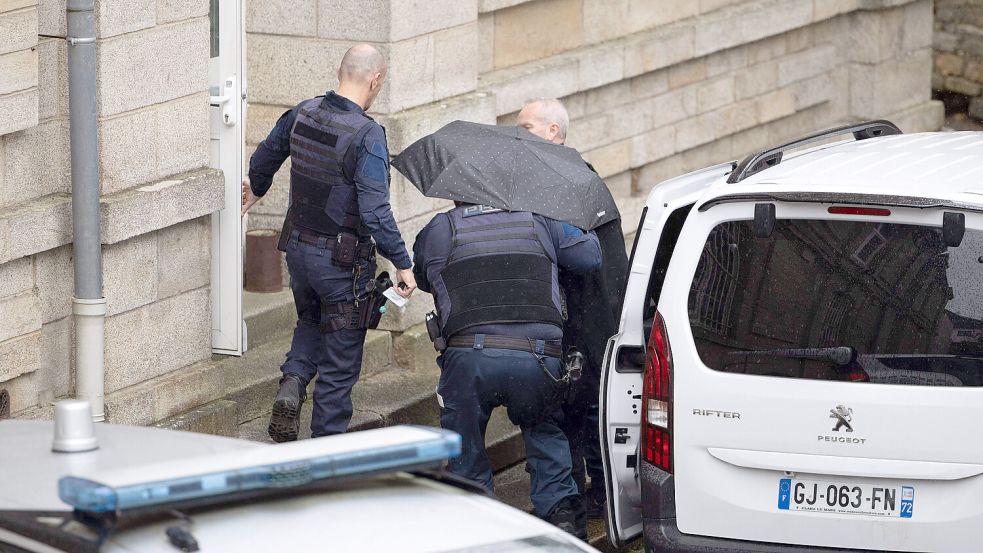 Ex-Chirurg Joël Le Scouarnec kommt, versteckt unter einem Regenschirm, zu seinem Prozess vor dem Strafgericht in Vannes an. Vier Monate soll der Prozess dauern. Foto: IMAGO/Raphael Lafargue