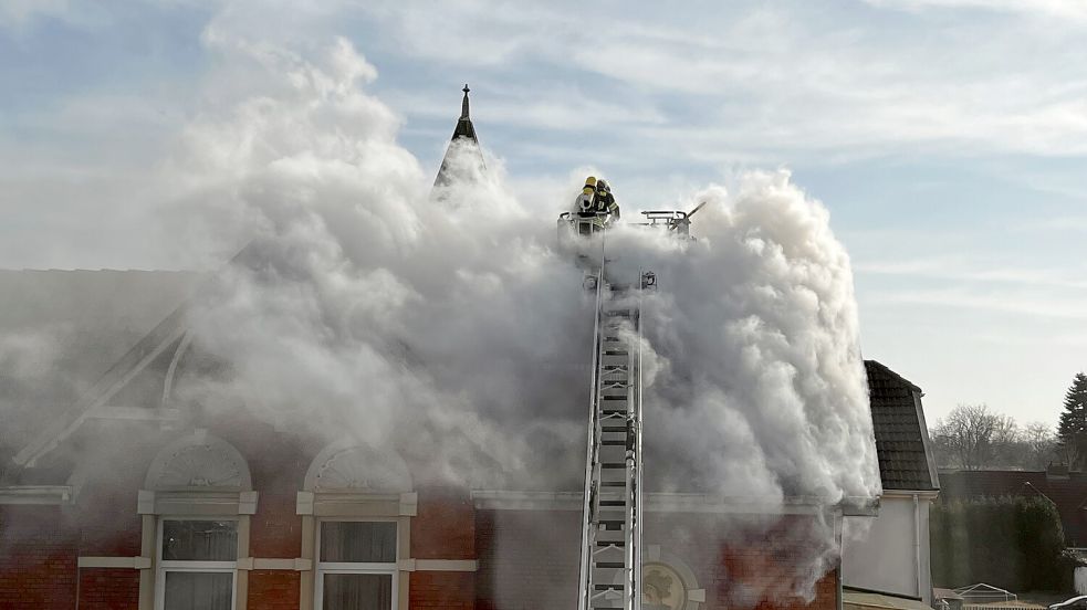 Die Feuerwehr bekämpfte das Feuer von oben durch ein rauchverhangenes Dach. Foto: Katja Löschen