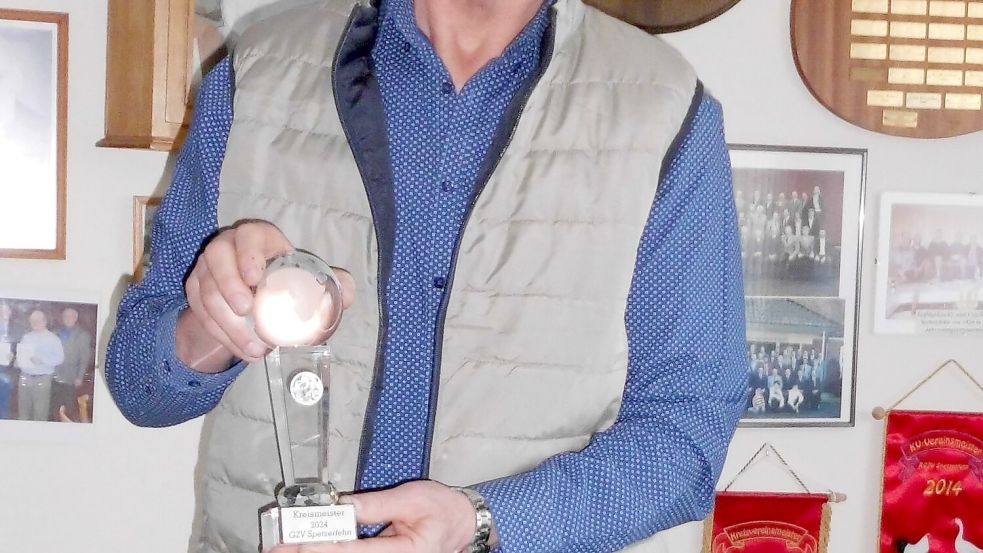 Reinhard Rademacher, Vorsitzender des Geflügelzuchtvereins Spetzerfehn-Großefehn, präsentiert den Glaspokal, den es für die Kreismeisterschaft gab. Foto: Trauernicht
