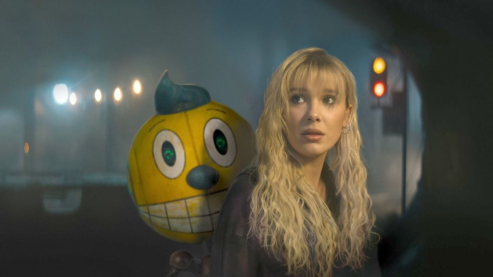 Mit dem Roboter Cosmo begibt sich Michelle (Millie Bobby Brown) auf eine gefährliche Suche nach ihrem totgeglaubten Bruder. Foto: -/Netflix /dpa