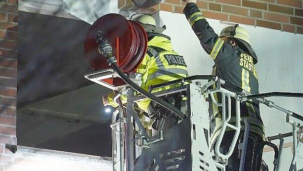 Die Feuerwehr verschafft sich Zugang zur Wohnung im zweiten Obergeschoss. Bei dem Brand in Diepholz wurden zwei Personen verletzt. Foto: NWM-TV
