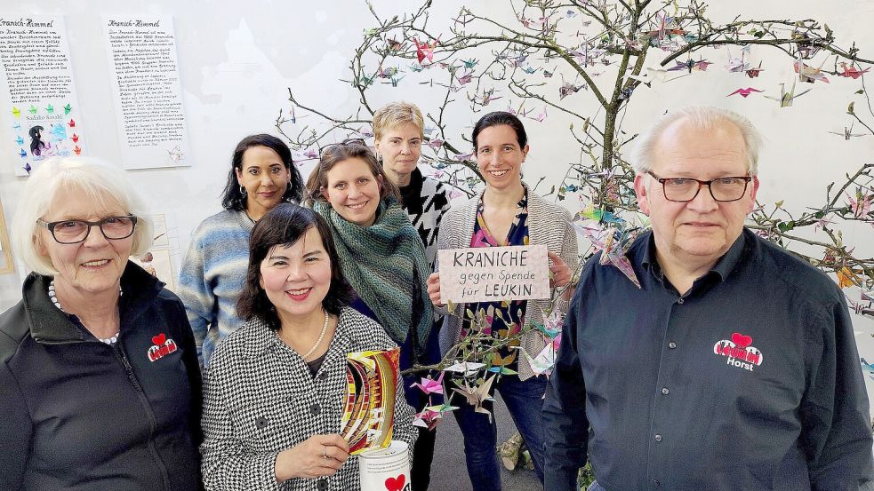 Chau Mui Nho (Dritte von links), überreichte vor dem kranichbehangenen Wunschbaum im Zwischenraum einen Umschlag mit 1000 Euro an Christa Lindenberg (links) und Horst Morgenstern (rechts) von Leukin. Begleitet wurde sie von Mona El Sirri (Zweite von links) und Eliese Giesenberg (Dritte von rechts). Die Spenden-Aktion mit Origami-Kranichen, die Ruth Moldenhauer (Zweite von rechts) und Carolin Kowalsky mit vielen anderen gebastelt haben, läuft dort weiter. Foto: Karin Böhmer