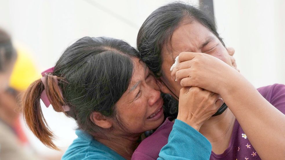 Verzweifelte Angehörige harren an der Unglücksstelle aus. Bei den meisten Bauarbeitern handelte es sich um Burmesen. Foto: Sakchai Lalit/AP/dpa