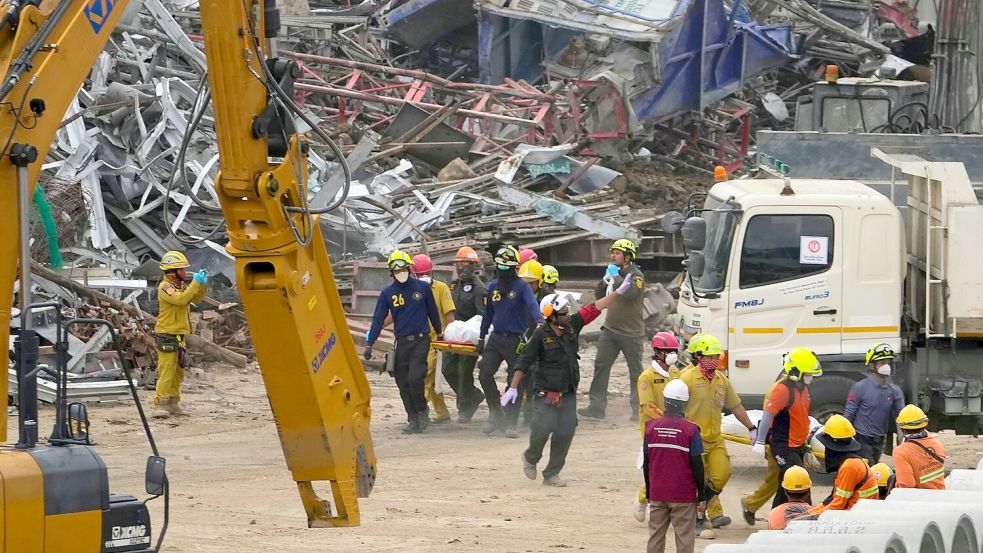 An den Trümmern eines Hochhauses in Bangkok laufen die Bergungs- und Rettungsarbeiten. Foto: Manish Swarup/AP/dpa