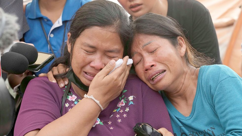 Menschen warten auf Nachrichten über Angehörige, die in den Trümmern des Hochhauses in Bangkok vermutet wurden. Foto: Sakchai Lalit/AP/dpa