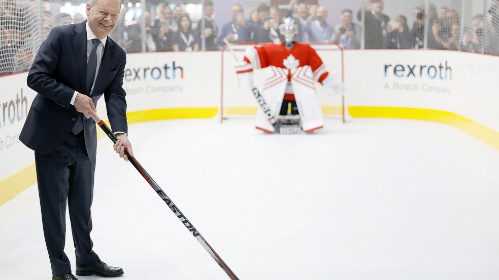Olaf Scholz (SPD), geschäftsführender Bundeskanzler, spielt am Stand von Canada Hockey gegen einen Roboter Torwart beim Eröffnungsrundgang auf der Industriemesse Hannover Messe 2025. Foto: DPA/Michael Matthey