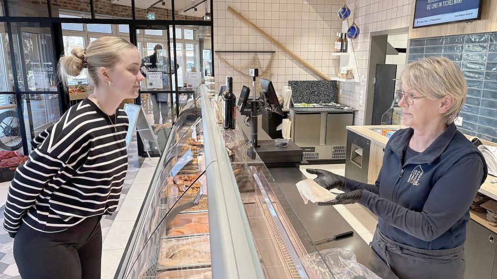 Monika Erhardts, Marktleiterin im Fischhaus in Tichelwarf, zeigt Kundin Ina Balssen ein Stück frisches Kabeljaufilet. Gerne gibt sie auch Tipps für die Zubereitung. Fotos: Walker