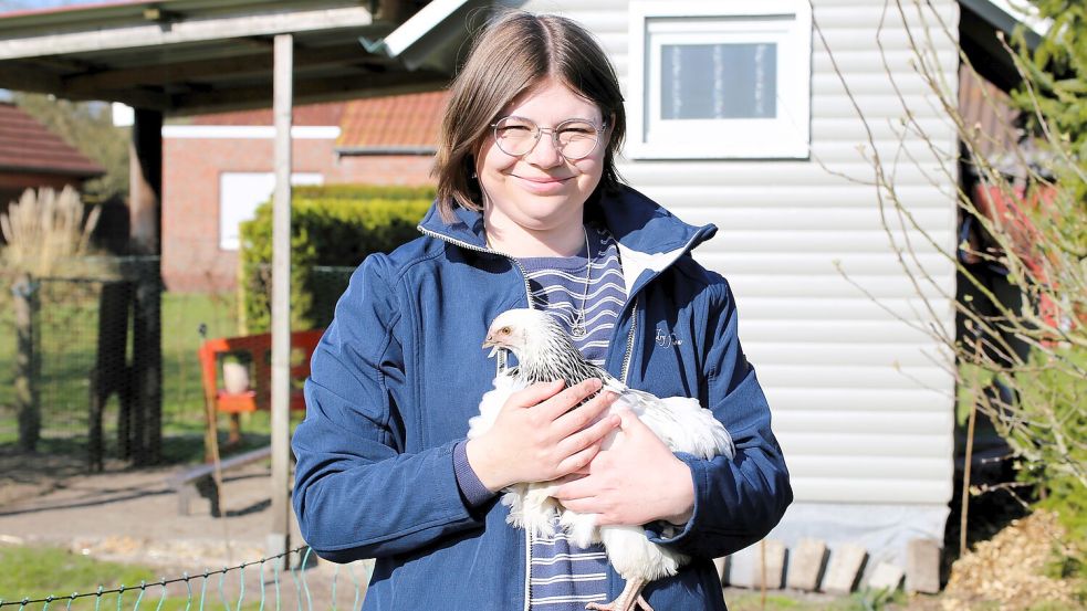 Fietes Retterin Kristina Meyer aus Zwischenbergen mit einer von Hahn Fietes neuen Hennen. Fiete selbst ist nach seinen Erfahrungen noch nicht so zutraulich wie Junghenne Klara. Foto: Böning