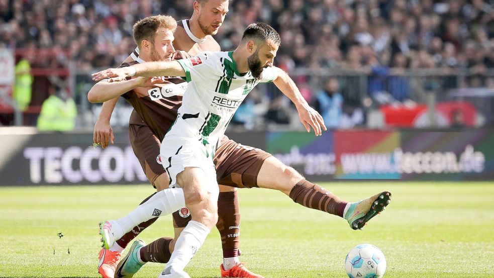 Möchengladbachs Franck Honorat (vorn) behauptet den Ball gegen die Hamburger Lars Ritzka (l) und Hauke Wahl. Foto: Christian Charisius/dpa