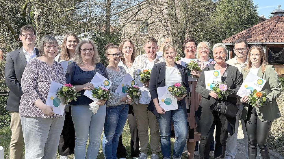 Machten ihren Abschluss als Pflegeassistenz in der Nichtschüler-Form: Christine Berger, Ute Breiter, Michaela Fecht, Miriam Hähnel, Beate Heinrich, Silvia Holzenkämper, Marie-Kristin Kromat, Antje Peters, Kenan Wienekamp, Roswitha Wietjes, Daniela Winner und Andrea Wolter. Begleitet wurden sie dabei unter anderem von Volker Hart (BBS1) und Petra Hoffmann (KVHS). Foto: Mieke Matthes