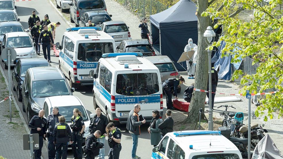 Polizisten und Beamte der Spurensicherung in weißen Schutzanzügen stehen an dem Ort, wo ein toter Mann gefunden wurde. Foto: Hannes P. Albert/dpa