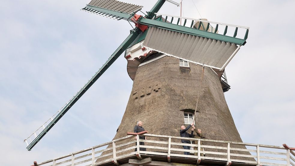 Die Flügel drehen sich. Jochen Wagner (von rechts) und Günther Siefken halten sie kurz fest, damit Mühlenbauer Diedrich Schlachter sie begutachten kann. Foto: Ullrich