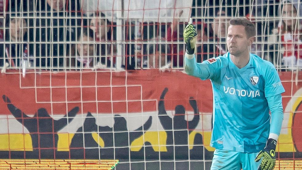 Bochums Keeper Patrick Drewes hält das Feuerzeug hoch, das ihn getroffen hat. Foto: Andreas Gora/dpa