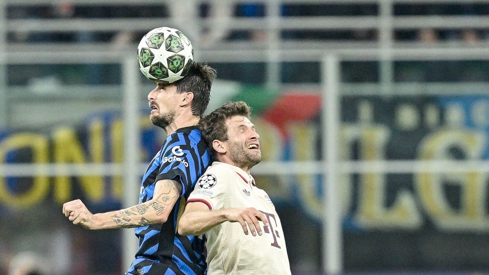 Thomas Müller (r) im Kopfball-Duell mit Mailands Francesco Acerbi. Foto: Sven Hoppe/dpa