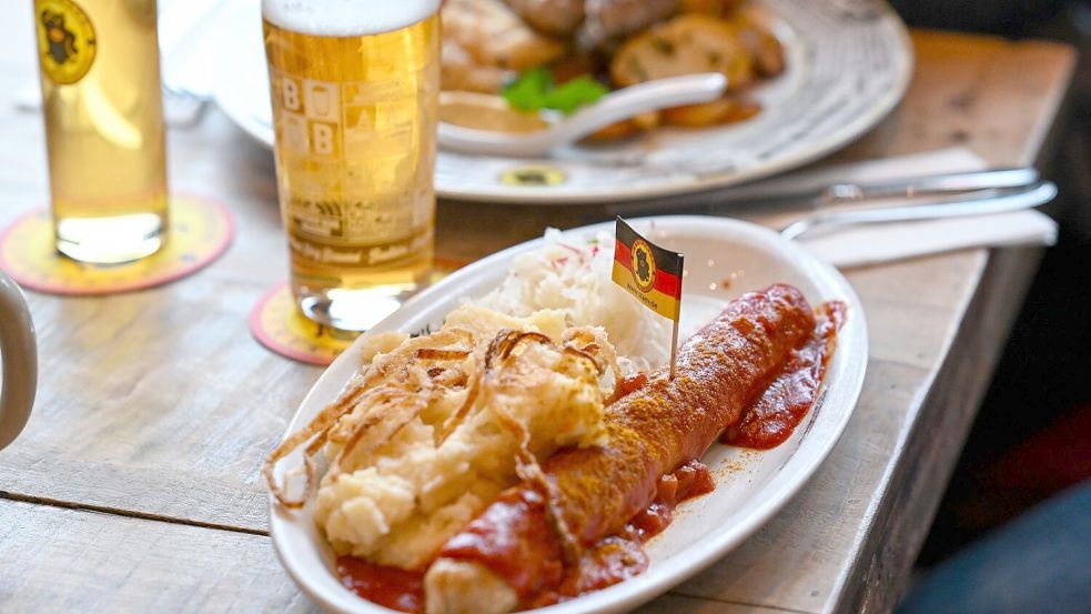 Wird die Currywurst günstiger, wenn die Mehrwertsteuer für Speisen in der Gastronomie sinkt? (Symbolbild) Foto: Jens Kalaene/dpa
