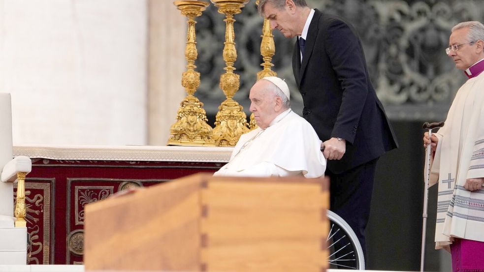 Papst Franziskus wird im Rollstuhl an dem Sarg des verstorbenen emeritierten Papstes Benedikt XVI. während öffentlichen Trauermesse für den emeritierten Papst Benedikt XVI. auf dem Petersplatz gefahren. (Archivbild) Foto: Andrew Medichini/AP/dpa
