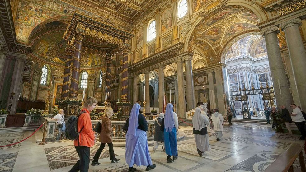 Gläubige und Nonnen gehen in der Basilika Santa Maria Maggiore, wo Papst Franziskus am 26. April beigesetzt wird. Foto: Alessandra Tarantino/AP/dpa
