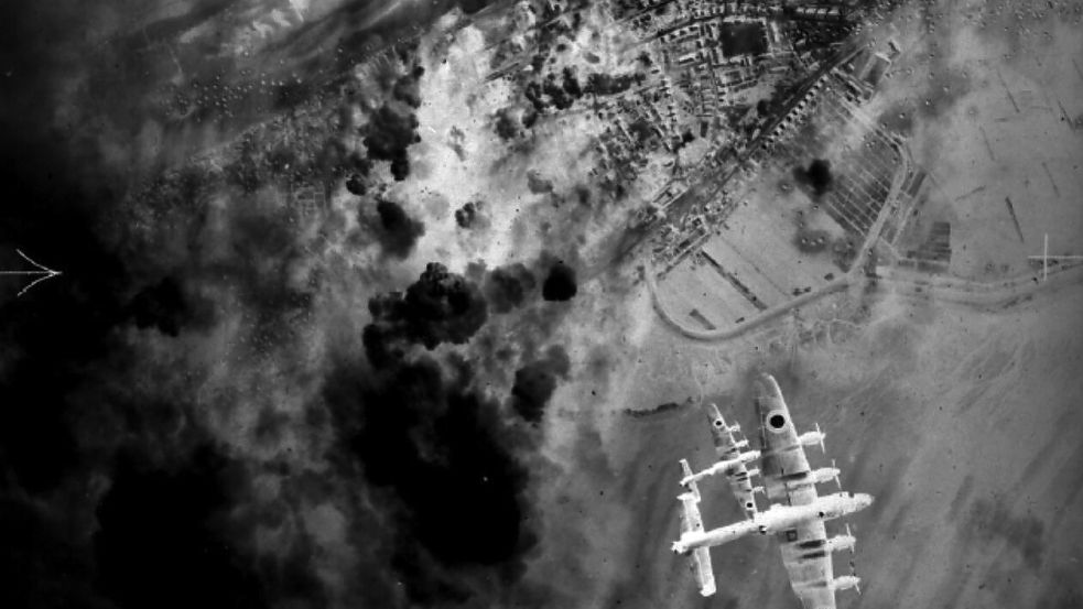 Zwei Lancaster-Bomber der britischen Royal Air Force über der Insel. Unten der Dorfgroden, links im Bild die Rauchschwaden der detonierenden Bomben. Foto: Inselarchiv/Jürgens