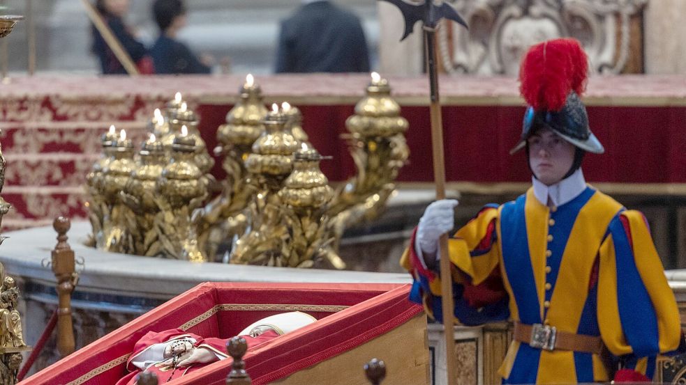 Ein Wachmann der Schweizergarde neben dem toten Papst. Foto: Oliver Weiken/dpa