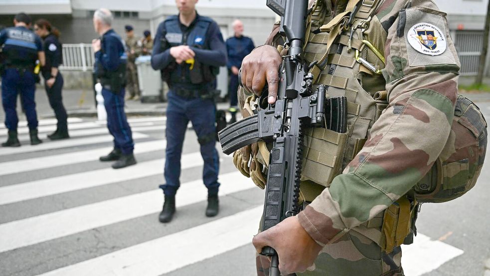 Französische Militärs und Polizisten sind in der Nähe des Gymnasiums im Einsatz. Foto: Loic Venance/AFP/dpa