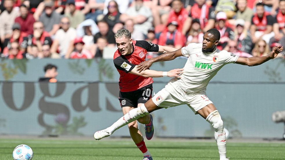 Florian Wirtz (l) leitet das 1:0 für Leverkusen ein. Foto: Federico Gambarini/dpa