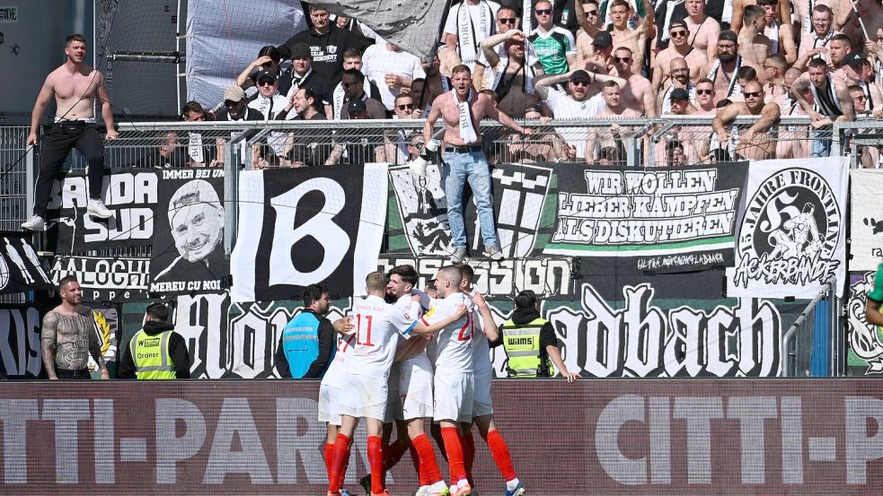 Kiels Spieler jubeln nach dem Treffer zum 1:0. Foto: Gregor Fischer/dpa