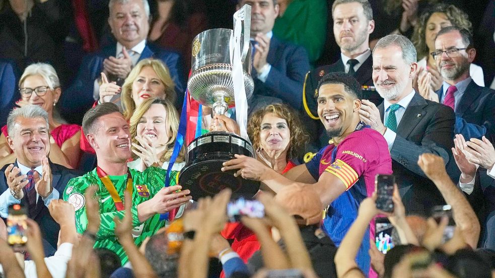 Der lange verletzte Marc-Andre ter Stegen (l) nahm gemeinsam mit Ersatzkapitän Ronald Araujo den Pokal entgegen. Foto: Jose Breton/AP/dpa