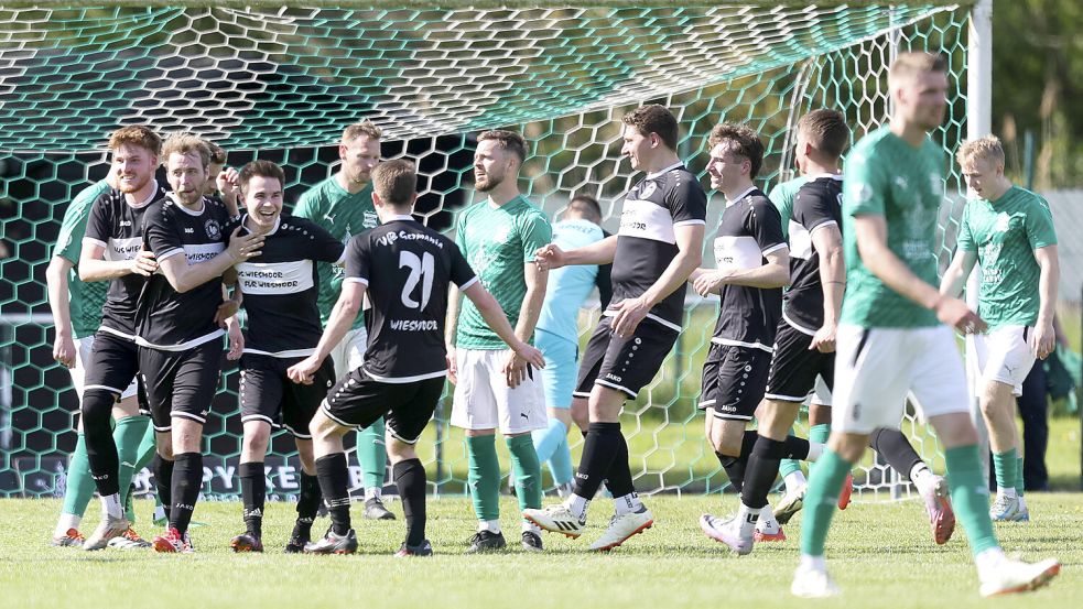 Freudestrahlend nimmt der Wiesmoorer Erik Homes (Dritter von links) die Gratulationen nach seinem Premierentor in der Bezirksliga entgegen. Fotos: Doden