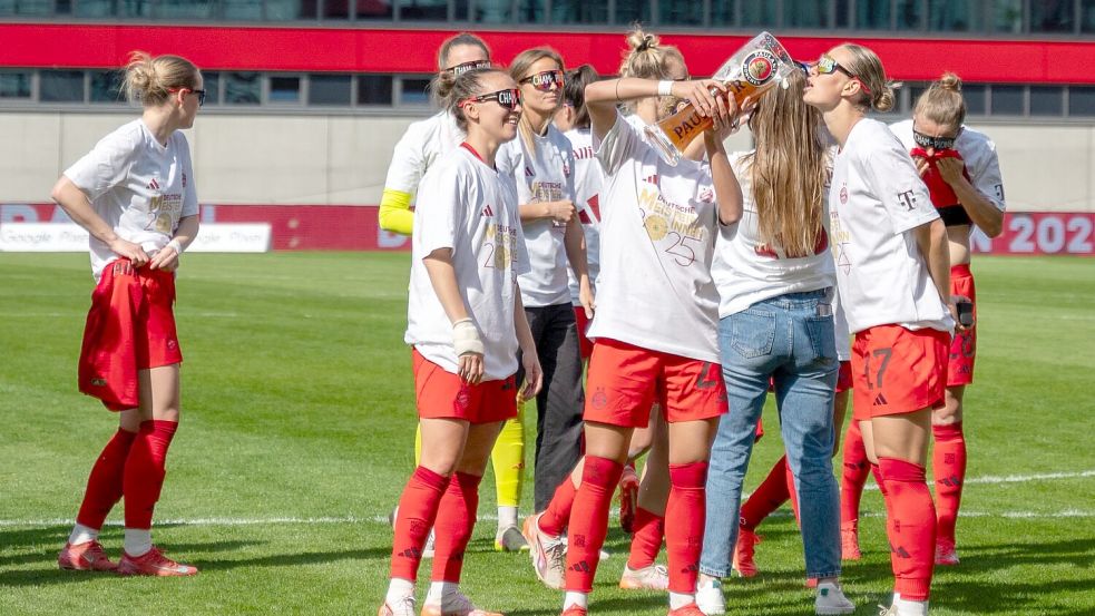 In Meister-Shirts und mit Bier feiern die Bayern-Fußballerinnen den Titel. Foto: Leonie Asendorpf/dpa