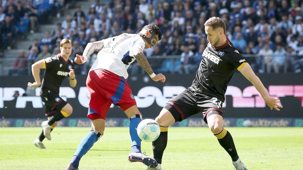 Der Hamburger SV und Davie Selke (l) patzen gegen Karlsruhe mit Christoph Kobald. Foto: Christian Charisius/dpa
