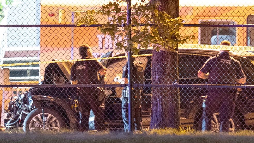 Polizisten untersuchen ein schwarzes Auto. Foto: Rich Lam/The Canadian Press/AP/dpa