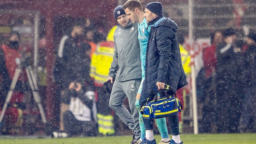 Folge des Feuerzeugwurfs: Torwart Patrick Drewes wird vom Platz geführt Foto: Andreas Gora/dpa