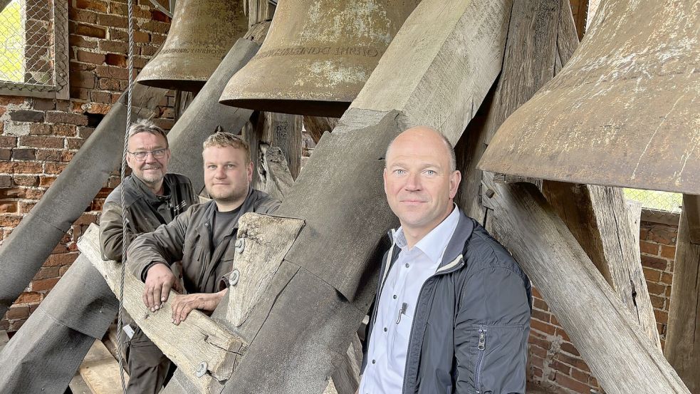 Udo Gravermann (von links) von der Fachfirma Glockenläute und Turmuhrensysteme Gravermann aus Gescher, sein Mitarbeiter Alexander Schlamann und Michael Penning vom Kirchenrat stehen im historischen Glockenturm. Im Turm sind unter anderem die Tragebalken für die drei Glocken erneuert worden. Foto: Carsten Ammermann