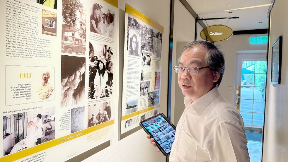 Der Historiker Nguyen Thanh Tung steht im berühmten Hotel Metropole vor Fotos der Schauspielerin Jane Fonda („Hanoi Jane“) und der Sängerin Joan Baez, die hier einst im Bunker Schutz suchten. Foto: Carola Frentzen/dpa