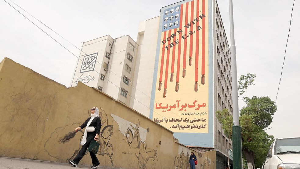 Schädel, die aus der US-Flagge triefen: Streetart mit dem Schriftzug "Down with the USA" begleitet die Verhandlungen im Atomstreit zwischen dem Iran und den USA. Foto: AFP/ATTA KENARE