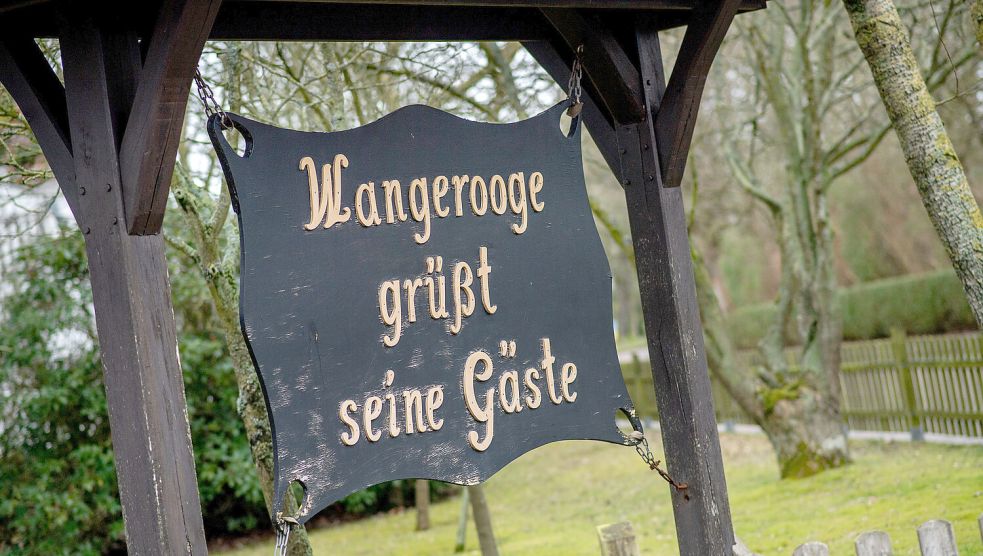 Ein Schild mit der Aufschrift „Wangerooge grüßt seine Gäste“ hängt vor dem Alten Leuchtturm am Bahnhof der Insel. Hauke-Christian Dittrich/dpa