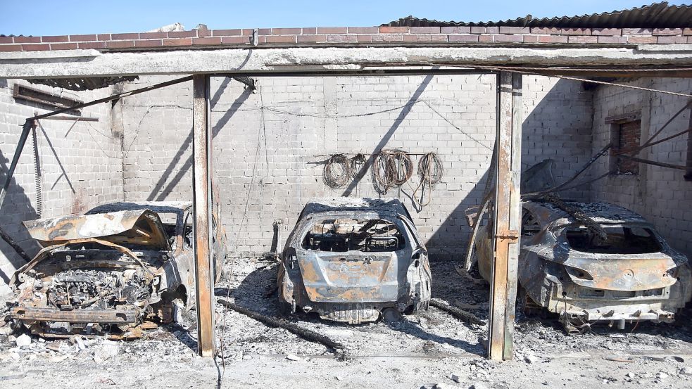 In dem ausgebrannten Nebengebäude des Bauernhofs in Leezdorf stehen die Stahlgerippe der durch das Feuer zerstörten Autos. Foto: Thomas Dirks
