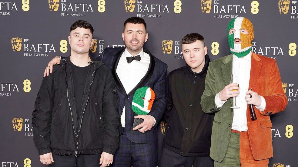 Die nun ins Visier von Ermittlungen geratene Band Kneecap wurde gemeinsam mit Regisseur und Autor Rich Peppiatt (Zweiter von links) bei den Bafta-Awards für einen gemeinsamen Film ausgezeichnet. Foto: Ian West/PA Wire/dpa