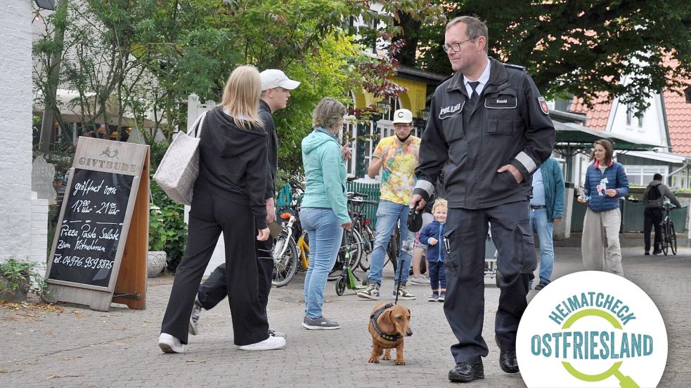 Auf Streife: André Basold und „Polizeidackel“ Hubert schauen in der Spiekerooger Dorfmitte nach dem Rechten. Foto: Susanne Ullrich