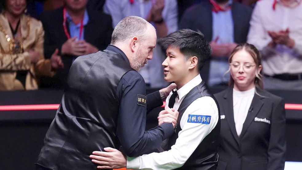 Zhao Xintong (r) besiegt im Finale Mark Williams und wird Weltmeister. Foto: Mike Egerton/PA Wire/dpa