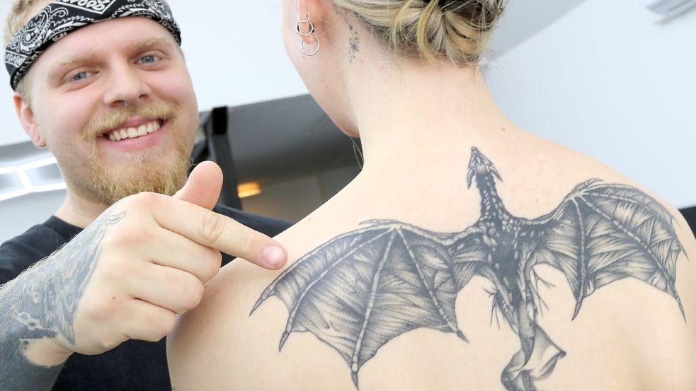 Hendrik Kleen zeigt eines der Tattoos, mit denen er den Körper seiner Freundin Svenja Wiese verziert hat. Foto: Nicole Böning