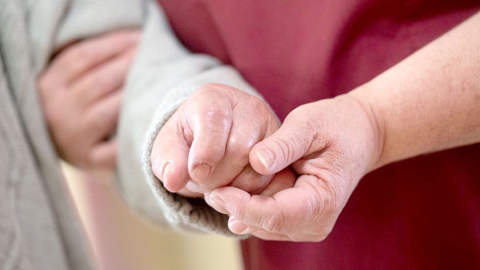 Eine Pflegekraft betreut in einem Seniorenhaus einen Bewohner. Foto: Marijan Murat/dpa