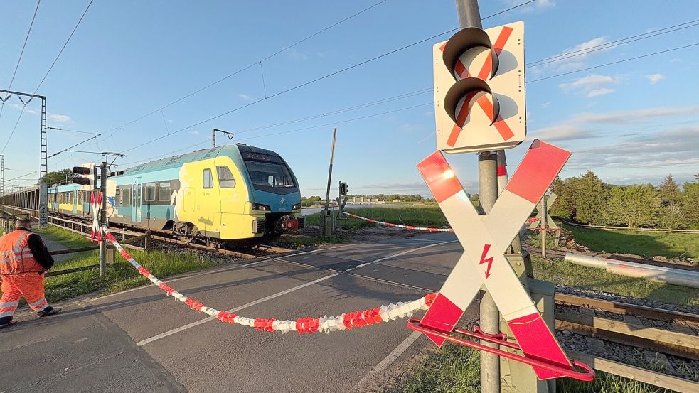 Die Signale und Bahnschranken am Übergang Esklumer Straße wurden erneuert. Während der Arbeiten musste ein Sicherungsposten den Übergang mit einem speziellen Flatterband sichern, wenn ein Zug kommt. Foto: Ammermann