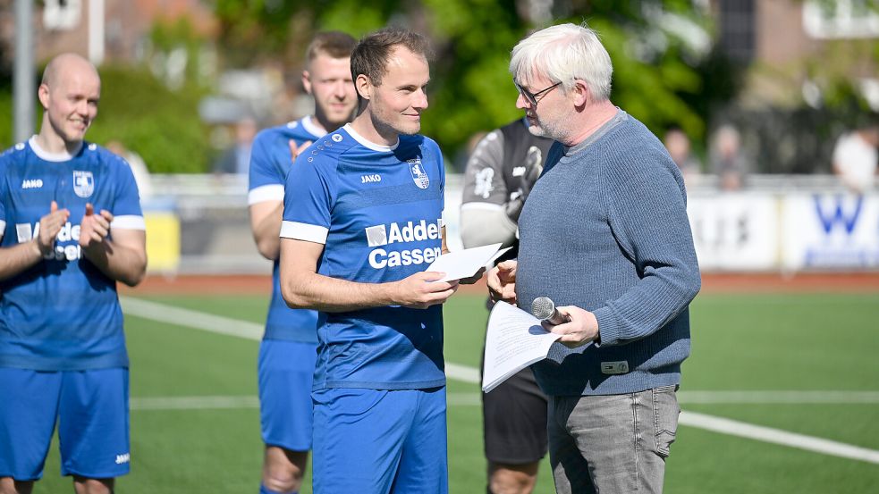 Esens’ Vereinsvorsitzender Holger Janssen (rechts) ehrte und verabschiedete Manuel Meints, der im Sommer in die Reserve wechselt. Foto: Jens Doden, Blomberg