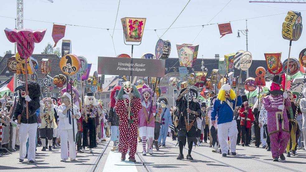 Auch Fasnächtler begleiten die Delegationen auf der Parade durch die Stadt. Foto: Georgios Kefalas/KEYSTONE/dpa