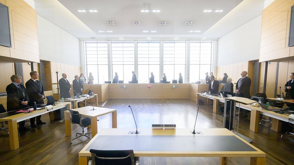 Die Verfahrensbeteiligten im Prozess um den VW-Abgasskandal - bis auf die vier Angeklagten - stehen zu Prozessbeginn im Gerichtssaal im Landgericht Braunschweig. Foto: Julian Stratenschulte/dpa