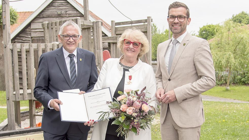 Landrat Olaf Meinen (links) übergab Manuela Stadtlander-Lüschen Medaille und Urkunde. Auch der Wiesmoorer Bürgermeister Sven Lübbers freute sich mit. Foto: Landkreis Aurich