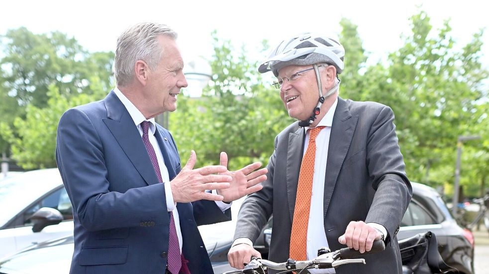 Mit Helm und Fahrrad kommt Stephan Weil (r) zur Wahl, bei der auch Christian Wulff zu Gast ist. Foto: Julian Stratenschulte/dpa