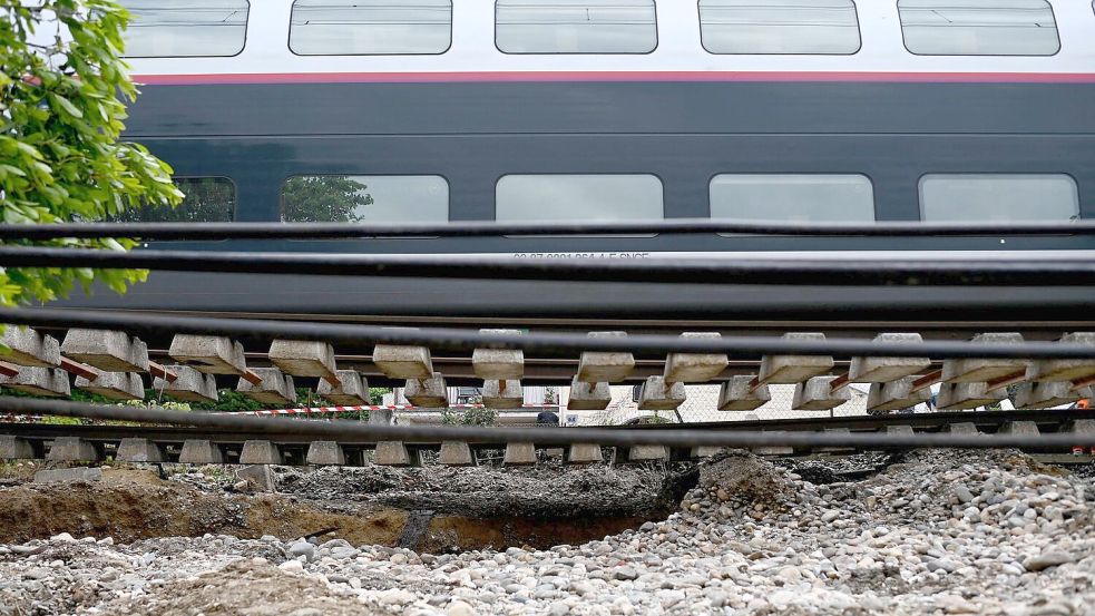 Dieser Zug musste anhalten, weil der Schotter unter den Schienen nach heftigen Regenfällen wegbrach. Foto: Christophe Archambault/AFP/dpa