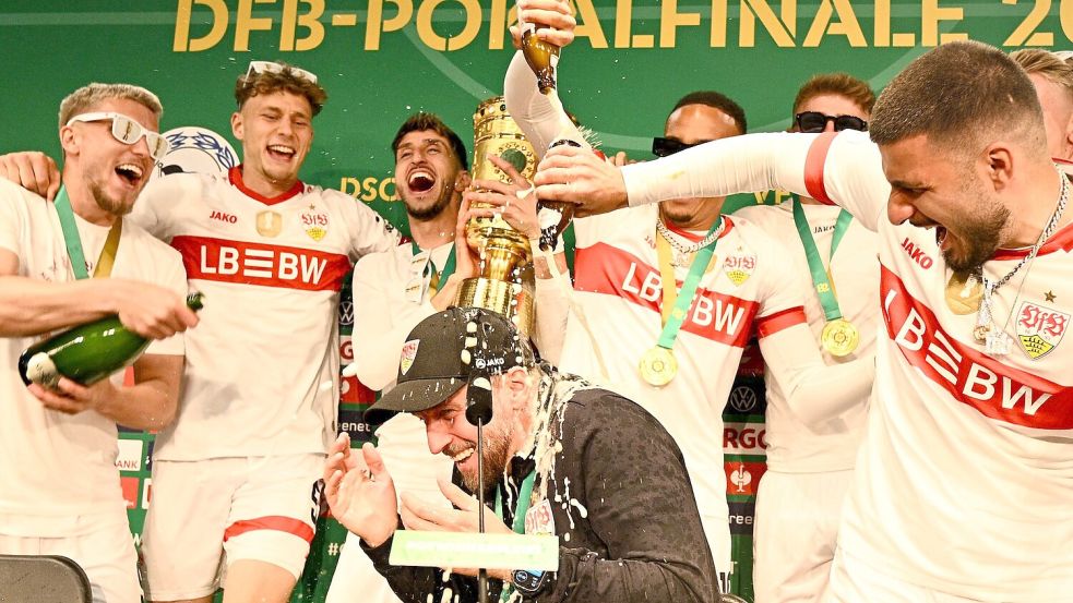 Die Pokalsieger überraschten ihren Trainer mit einer Sektdusche. Foto: Tom Weller/dpa